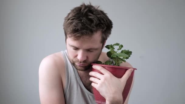 Μεθυσμένος στρεσαρισμένος άντρας να κάθεται αγκαλιάζοντας μια κατσαρόλα με λουλούδι να είναι μόνος. — Αρχείο Βίντεο