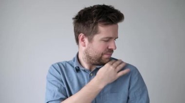 Caucasian mature man dusting off his shoulder.