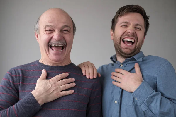 Двоє чоловіків і син сміються над своїм другом жартом, що має гарний настрій . — стокове фото