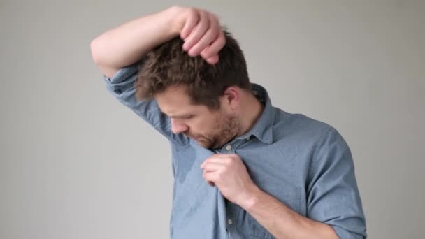 Junger Mann in blauem Hemd mit Schweißflecken darauf. — Stockvideo