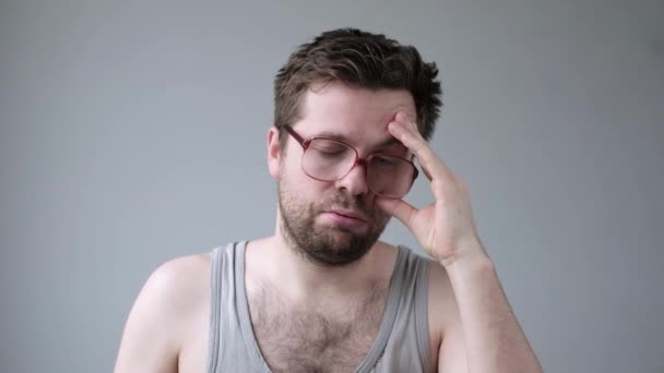 Młody, zmęczony mężczyzna w wielkich okularach pod wpływem stresu mający problemy z bezsennością — Wideo stockowe