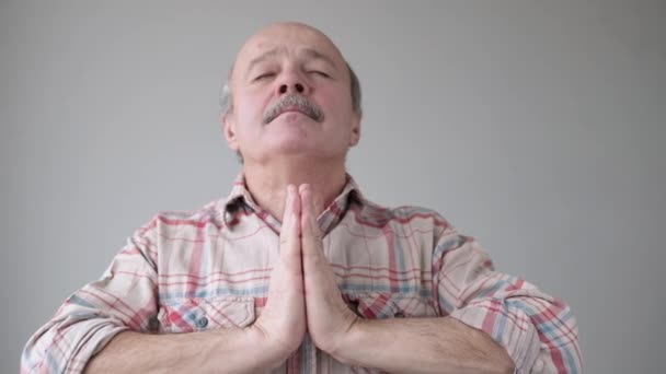 Calma relaxa o homem hispânico sênior de pé com as mãos da palma da mão, olhos fechados e fazendo ioga meditando . — Vídeo de Stock