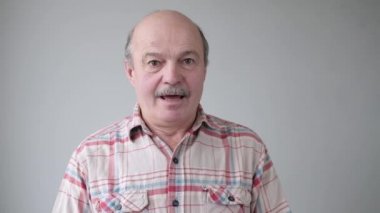 Yaşlı adam endişeli bir ifadeyle tırnaklarını yiyor.