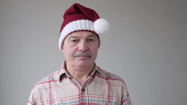 Sênior hispânico triste homem tirando chapéu de Natal vermelho, porque as férias acabaram . — Vídeo de Stock