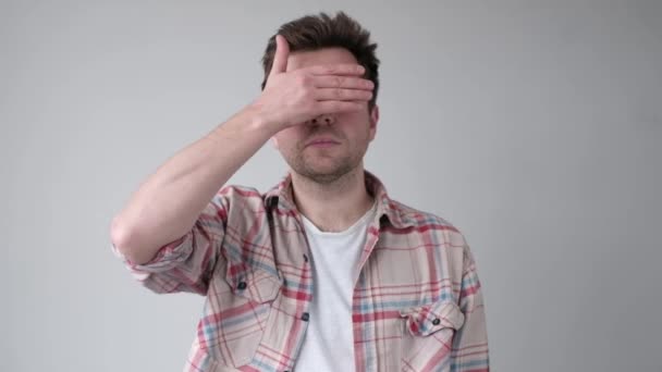 Young man covering his face by hand and peeping at the end. — Stock Video