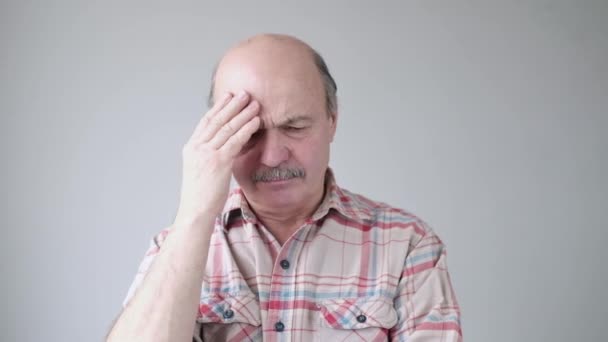 Hombre hispano mayor tratando de recordar algo o teniendo un terrible dolor de cabeza . — Vídeo de stock