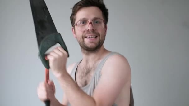 Happy handyman holding dancing with saw and hammer. He is happy to start renovation — Stockvideo