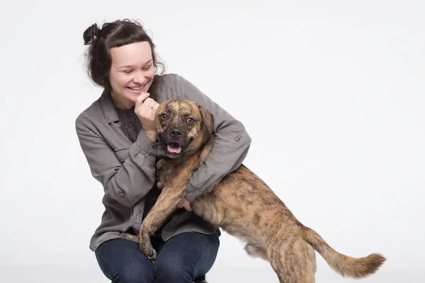 Jovem mulher bonita abraçando seu cão. Amizade entre homem e animal de estimação doméstico — Fotografia de Stock