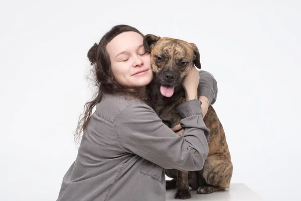 Jovem mulher bonita abraçando seu cão. feliz proprietário abraçando seu melhor amigo pet — Fotografia de Stock