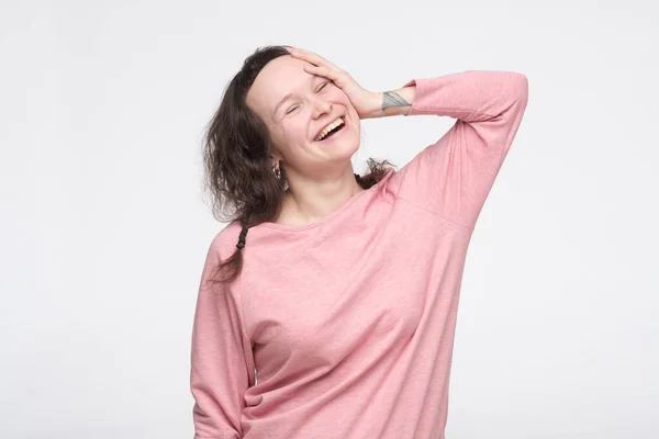 Женщина в розовом пуловере смеется над шуткой или рада, что вспомнила важный факт . — стоковое фото