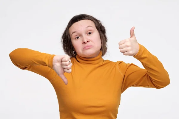 Menina bonita fazendo bom mau sinal mostrando polegar para cima e para baixo . — Fotografia de Stock