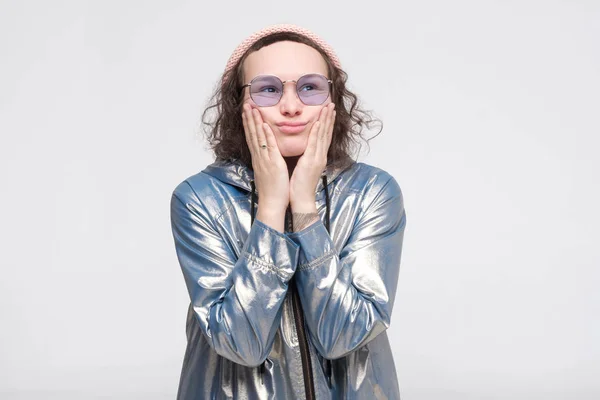 Tänker sorgsen flicka i glasögon och rosa hatt isolerad på vit bakgrund — Stockfoto