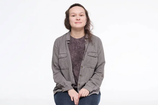 Smiling young caucasian woman sitting lookibn at camera — Stock Photo, Image