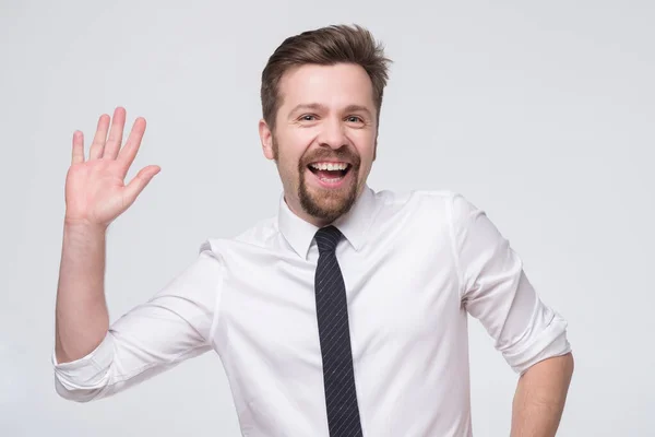 Handsome caucasian man in tie and whie shirt with glasses saluting waving hand. — ストック写真