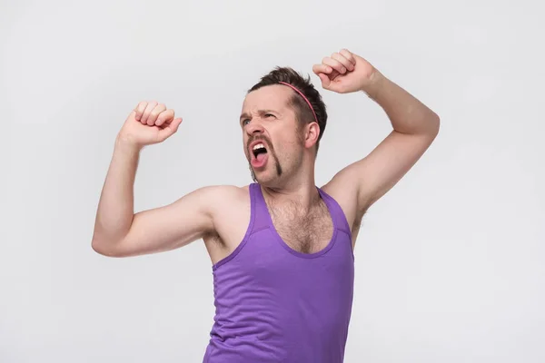 Hombre divertido con bigote mostrando sus músculos sobre fondo gris — Foto de Stock
