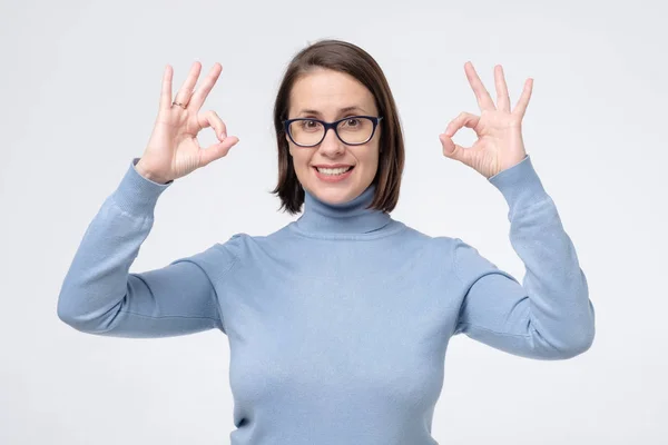 Mulher madura branca com sorriso largo usando óculos mostrando símbolo ok com os dedos . — Fotografia de Stock
