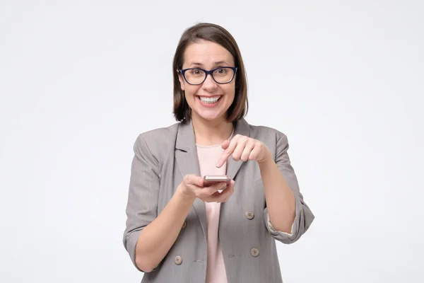 Žena držící mobilní telefon kontrolovat, co koupit v on-line obchodě. — Stock fotografie