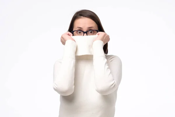 Displeased young woman in glasses wearing a high neck white sweater — Stock Photo, Image