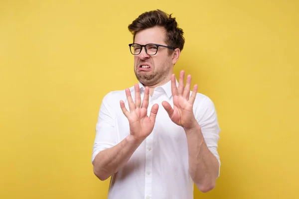 Aantrekkelijke man in bril en wit shirt toont weigering gebaar, wil niet deelnemen aan vergadering — Stockfoto