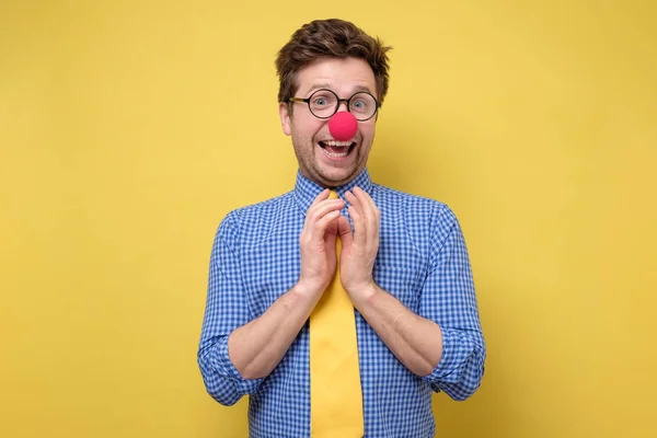 Hombre con nariz de payaso rojo y corbata amarilla impactada. Día tonto el primero de abril — Foto de Stock