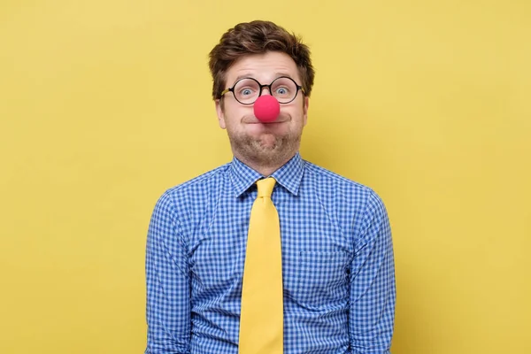 Giovane bell'uomo con il naso rosso clown che soffia guance . — Foto Stock