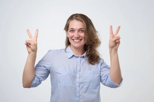 Молодая женщина показывает два пальца, позитивный или мирный жест . — стоковое фото