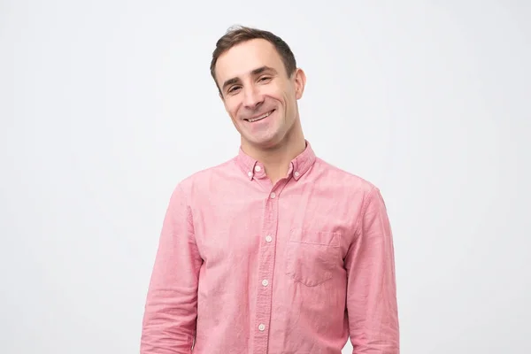 Jeune homme souriant debout avec les bras croisés sur fond gris — Photo