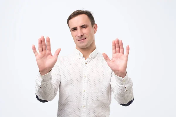 Atraktivní dospělý muž ukazuje odmítavé gesto, nechce se účastnit setkání — Stock fotografie