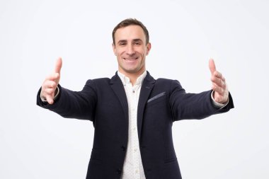 Çok mutlu takım elbiseli adam elleri açık duruyor. Ailelerini ya da arkadaşlarını karşılıyor..