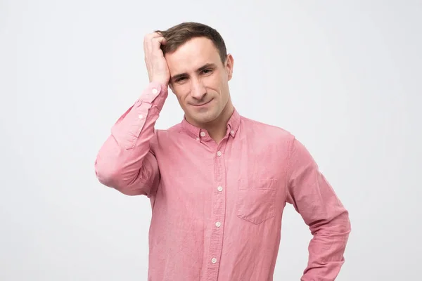 Man in roze shirt wordt geschokt, hij probeert te onthouden belangrijke informatie voor de ontmoeting. — Stockfoto