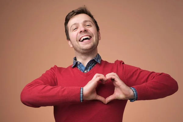 Jongeman toont hart gebaar met handen. glimlachen millennial man guy stuur liefde naar zijn vriendin. — Stockfoto