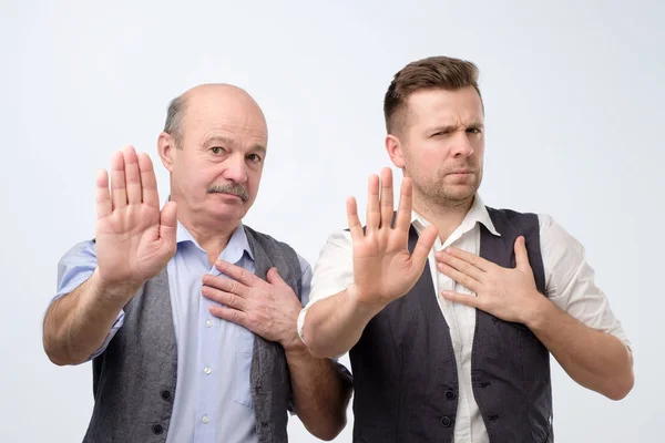 Two caucasian mature men showing stop sign pushing someone away. — 스톡 사진