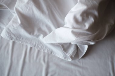 Rippled cotton fabric bedding after sleeping. Top view