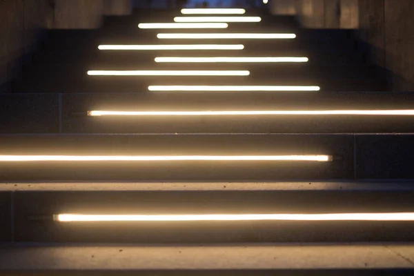 Line of lighted stairs at night. Upwards view.