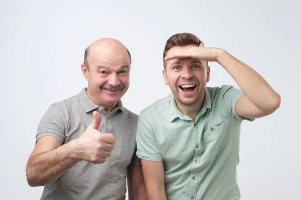 Emocionados hombres caucásicos padre e hijo se sorprenden mostrando pulgar hacia arriba — Foto de Stock