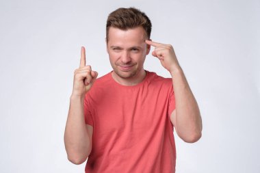 İşaret parmağı gösteren tatmin olmuş genç bir adam fikir üretiyor..