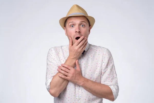 Joven hombre guapo en el sombrero de verano habiendo sorprendido la expresión facial — Foto de Stock