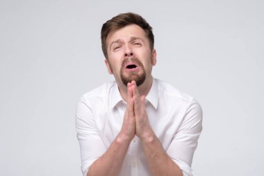 Duygusal adam ellerini birbirine kenetliyor. Af dilerken kaşlarını çatıyor.