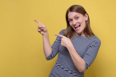 Sarı duvardaki telif alanını gösteren neşeli kadın..