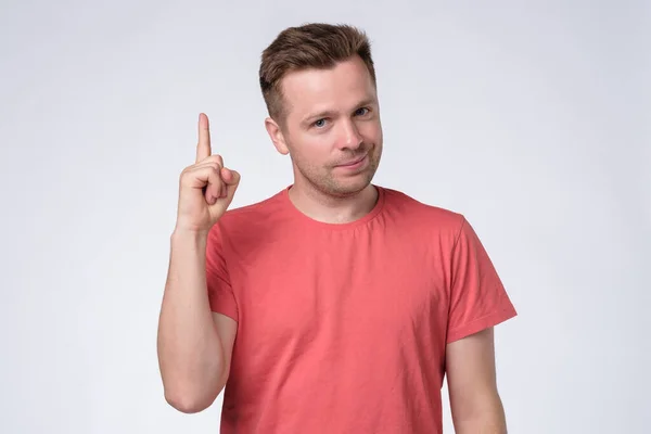 Satisfied young man showing index fingers up — Stock Photo, Image