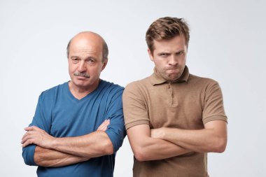 Two angry men father and son having angry grumpy feeling.