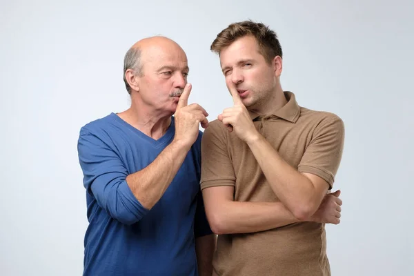 Bonito dois homens pai e filho fazendo gesto de silêncio — Fotografia de Stock