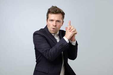 Genç işadamı bir silah hareketi yapıyor. Ateş etmeye hazırlanıyor ve gizli ajan gibi davranıyor. Stüdyo çekimi