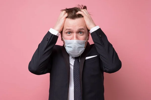 コロナウイルスのパンデミックによって強調されている医療用マスクのオスの若い白人男性 スタジオショット — ストック写真