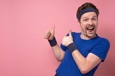 Komik bıyıklı, pembe duvarda izole edilmiş, mutlu, beyaz bir adam. Spor salonunda sağlıklı yaşam tarzını onaylayın..