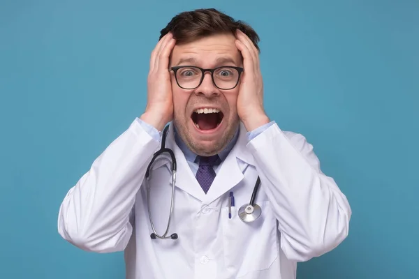 Läkare skriker i panik, håller händerna på huvudet, får reda på skräckslagna nyheter — Stockfoto