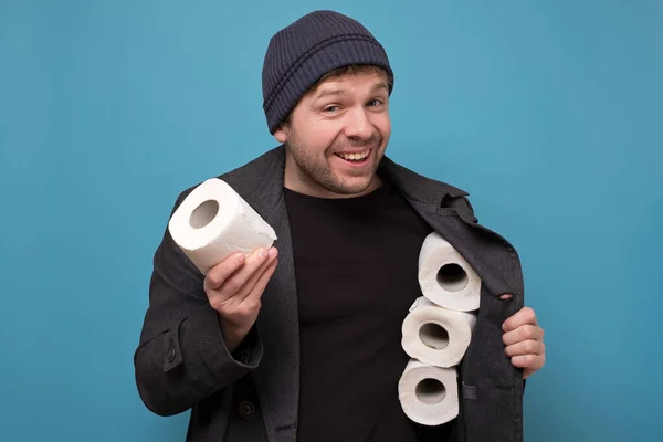 Junger kaukasischer Spekulant mit mehreren Rollen Toilettenpapier. Wollen Sie es kaufen? Defizit in Geschäften wegen Coronavirus-Panik — Stockbild Junger Kaukasischer Spekulant Mit Mehreren Rollen Toilettenpapier Wollen Sie Kaufen — Stockfoto