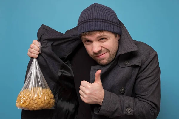 食料を売るのが苦手だ 帽子とコートのディーラーはパスタを購入する提供しています パニックのために食べ物の赤字 スタジオショット — ストック写真