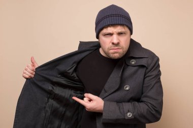 Kafkasyalı genç spekülatör paltosunu boş bir yere doğrultup bütçe açığını gizliyor. Konsepti satın almak ister misin? Koronavirüs paniği nedeniyle dükkanlarda açık