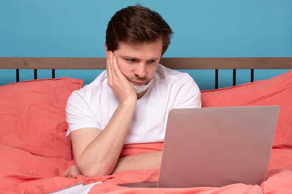 Чоловік Лежить Ліжку Своїм Ноутбуком Який Намагається Працювати Карантині Студійний — стокове фото